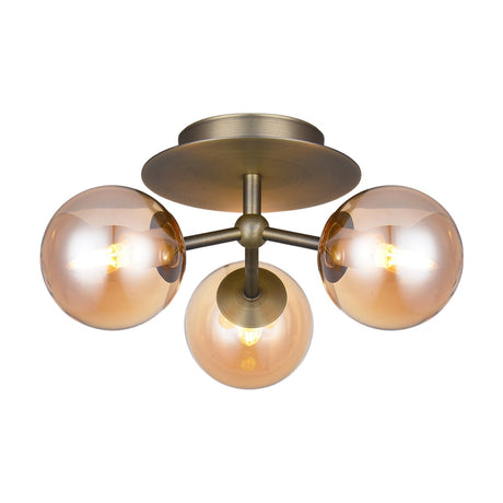 Atom Trio 3 Light Flush Ceiling Light in antique brass, featuring three amber glass globe shades on a central hub with round ceiling plate, shown on a plain white background.
