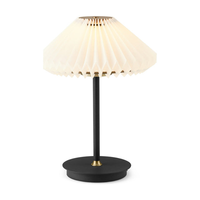 Paris LED Go Clean Rechargeable Table Lamp with white pleated paper shade, slim black stem, and round black base with brass accents on a plain white background.