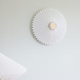Paris Clean Wall Flush Ceiling Light 40cm in white with a pleated paper shade, pointed rim edge, and antique brass centre disc, mounted on a light grey wall.