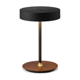 On the Move rechargeable LED table lamp with a black drum shade on a slim black stem, brass collar, and round walnut wood base, on a plain white background.