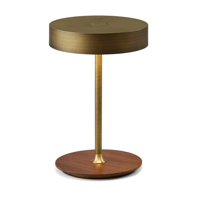 On the Move LED Rechargeable Table Lamp in antique brass with round drum shade, slim brass stem, and walnut disc base, shown on a plain white background.