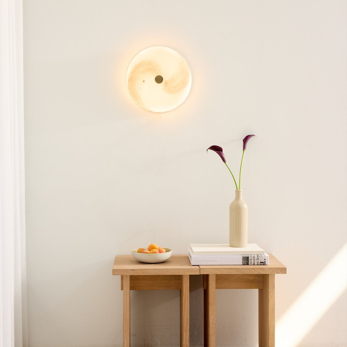 Stockholm LED Dimmable Flush Ceiling Light in grey marbled opal glass with a central brass boss, glowing softly on a wall above a wooden console table.