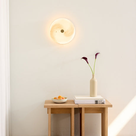 Stockholm LED Dimmable Flush Ceiling Light in grey marbled opal glass with a central brass boss, glowing softly on a wall above a wooden console table.