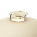 Close-up of the cream Stepp LED Outdoor Table Lamp, showing its round flared shade with stepped cap on short posts glowing above a domed base, on a white background.