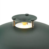 Close-up of the Stepp LED Outdoor Table Lamp in dark green, showing the shallow domed cap on brass posts with a glowing LED ring against the rounded body.