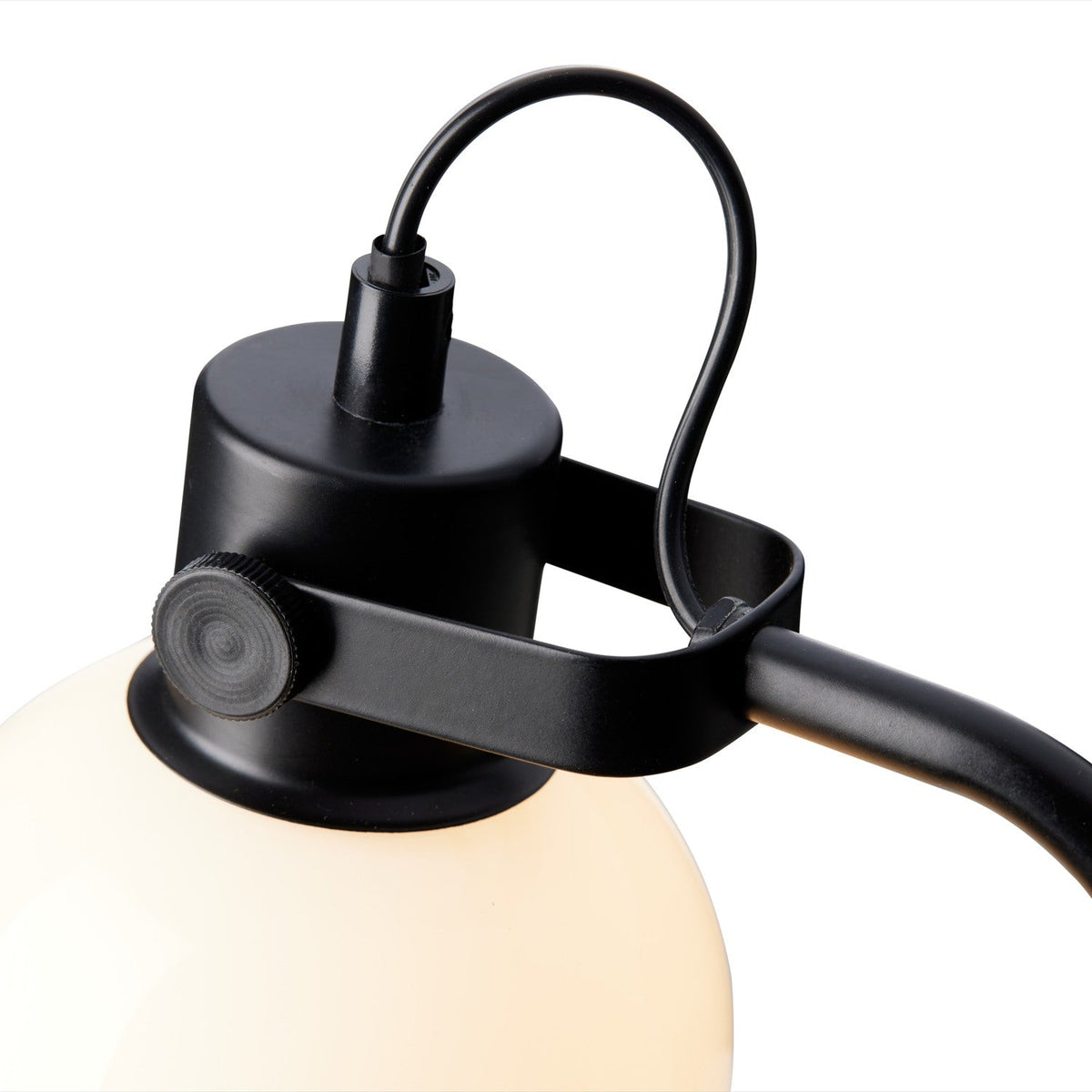 Close-up of the Glow Table Lamp's black metal fitting, showing the adjustable knuckle joint and band gripping the opal glass globe shade, on a white background.