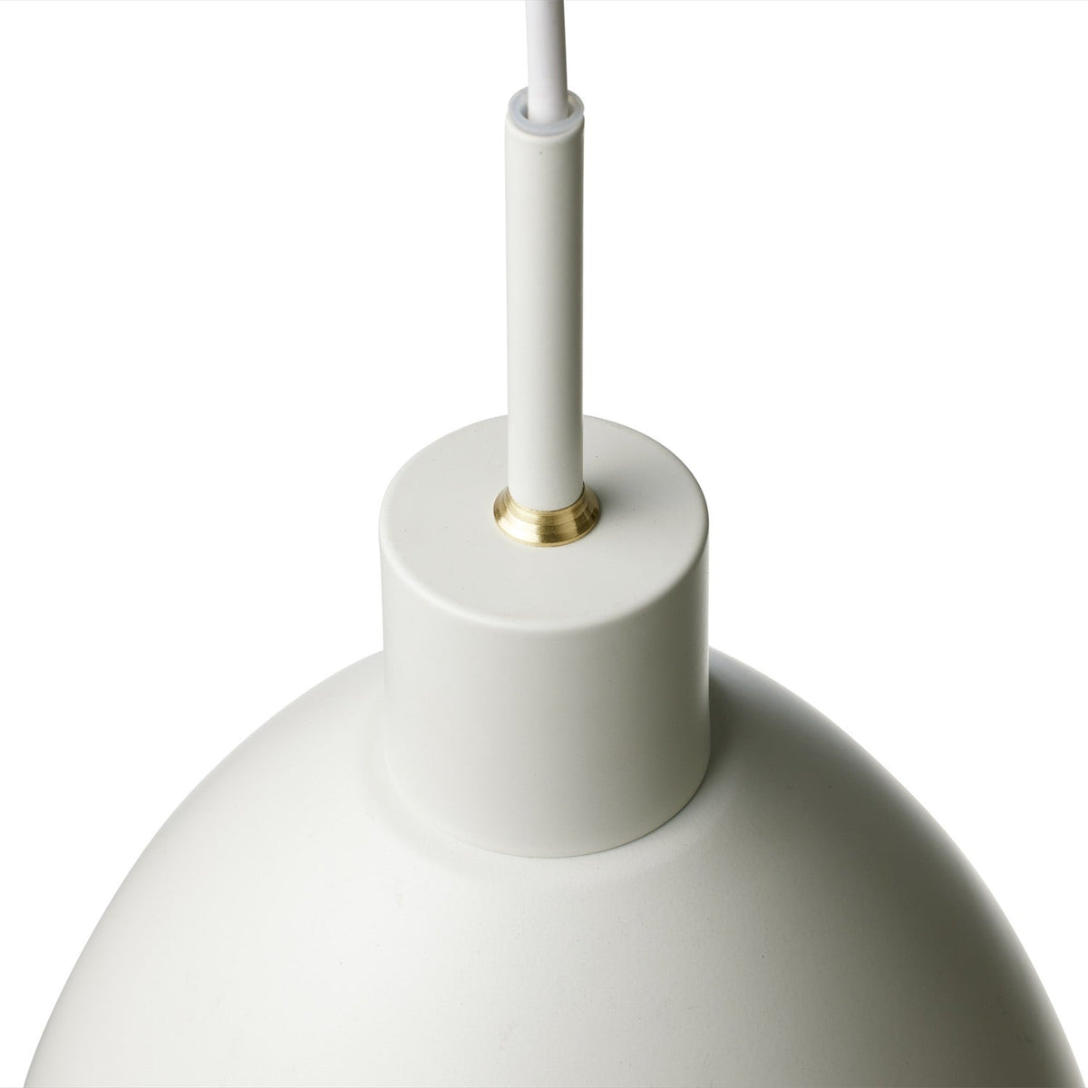Close-up of the Rock Pendant Light 20cm in white, showing the domed shade's smooth curve, brass detailing at the cord entry, and matt finish against a plain white background.