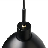 Close-up of the Rock Pendant Light 20cm in black, showing the matt shade's cylindrical top with brass detail and black cord against a plain white background.