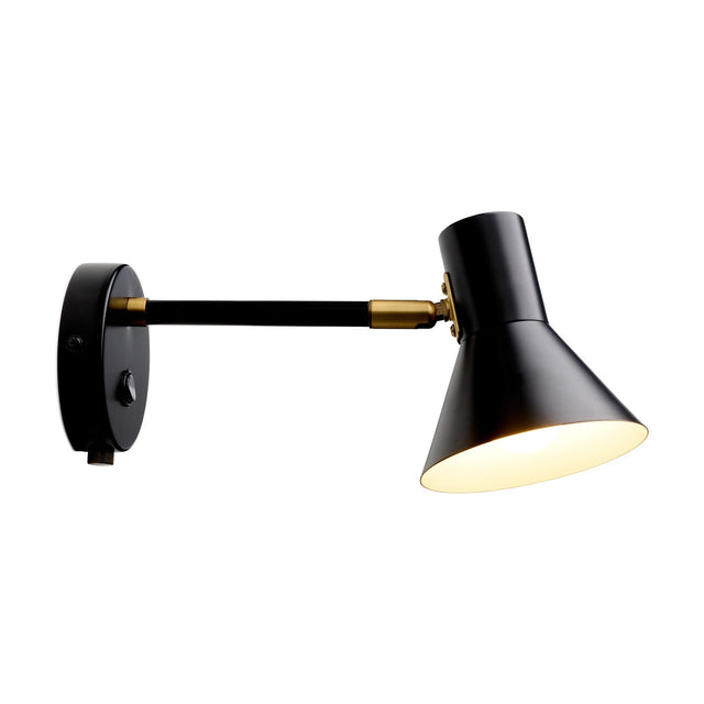 Style wall light in black and antique brass, with a straight arm from a round wall plate to a black cone shade on a brass knuckle joint, shown lit against a white background.