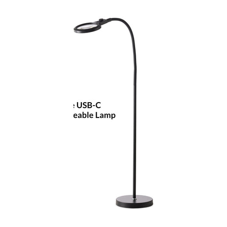 Magni Floor portable table lamp in black, with a round magnifying head on a tall flexible gooseneck arm rising from a flat round base, shown on a plain white background.