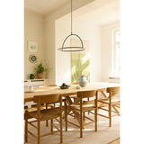 Tilt LED Ring Chandelier 40cm in black and brass, its horizontal lit ring and arching frame hung above a wooden dining table in a sunlit dining room.