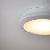 Close-up of the Push Rechargeable Flush Ceiling Light 18cm in white, showing its round fitting, ribbed rim, prismatic diffuser and small sensor dome, mounted on a plain white ceiling.