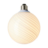 Colors Candy Bulb 12.5cm in opal glass with a twisted flute design, spiral ribs from neck to base, warm white diffused glow, silver-tone E27 fitting, on a plain white background.