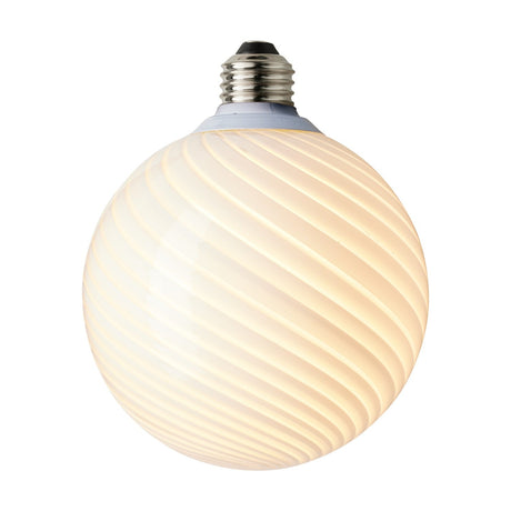 Colors Candy Bulb 12.5cm in opal glass with a twisted flute design, spiral ribs from neck to base, warm white diffused glow, silver-tone E27 fitting, on a plain white background.