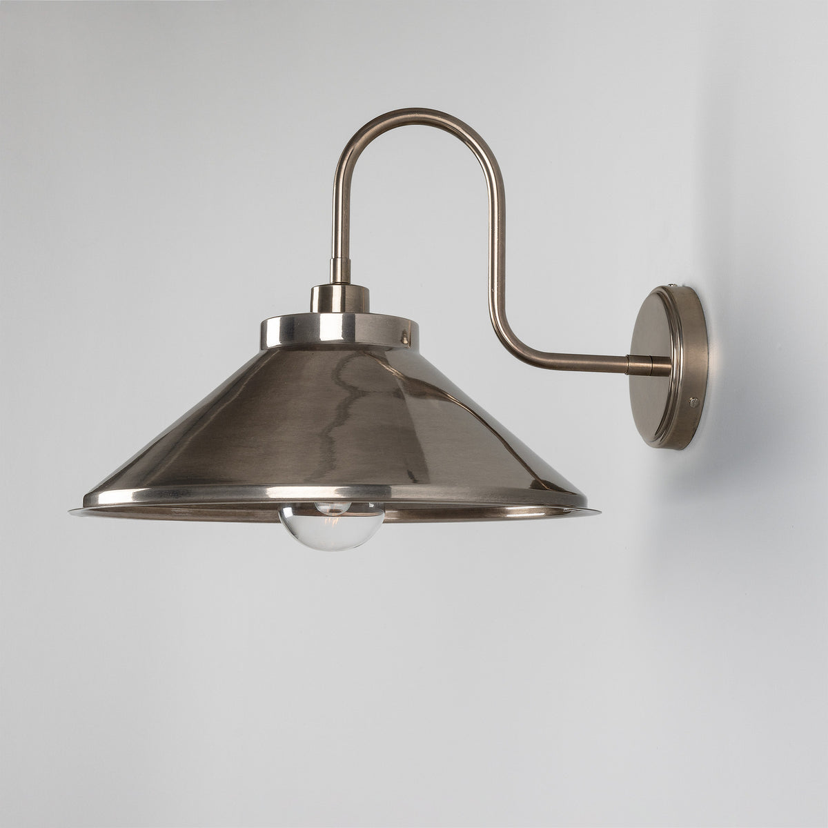 Halvery Brass Swan Neck Wall Light IP65 with curved arm, round wall backplate, and wide cone shade over a single bulb, shown on a plain light grey background.
