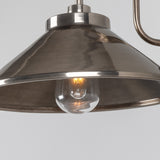 Close-up of the Halvery Brass Swan Neck Wall Light's cone shade in a dark metal finish with a visible bulb, set against a plain grey background.