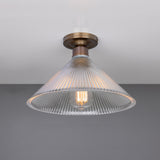 Hanoi Ribbed Glass Flush Ceiling Light with a cone-shaped clear ribbed glass shade and brass ceiling plate, shown lit with an exposed E27 bulb against a plain grey background.
