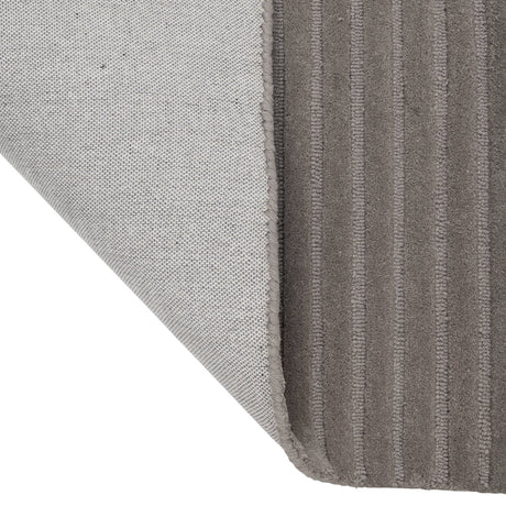 Haraan Rug 300 x 200cm in Brown, folded corner showing ribbed wool pile texture on top and a woven grey backing beneath.
