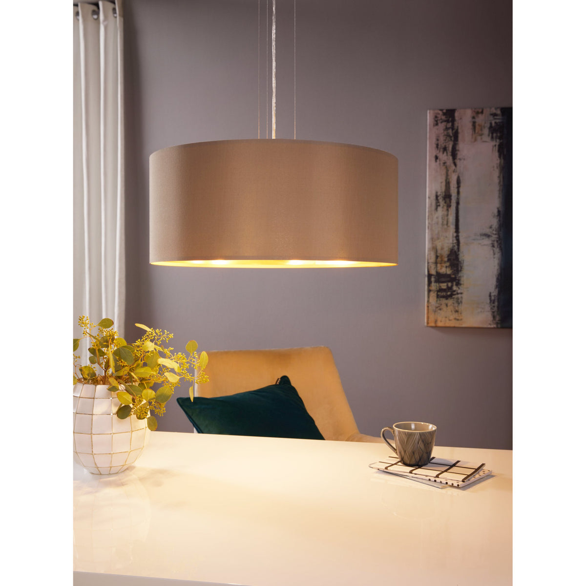Hasanne 3-light pendant with wide taupe fabric drum shade and gold lining, satin nickel ceiling rose, hung above a dining table in a grey-walled room.