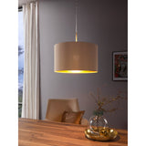 Hasanne fabric pendant light with taupe drum shade and gold interior lining, satin nickel ceiling canopy, shown above a dining table in a grey-walled room.