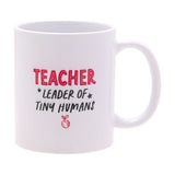 White stoneware mug with gloss finish, reading "TEACHER" in red and "LEADER OF TINY HUMANS" in black with a red apple icon, C-shaped handle, on a white background.