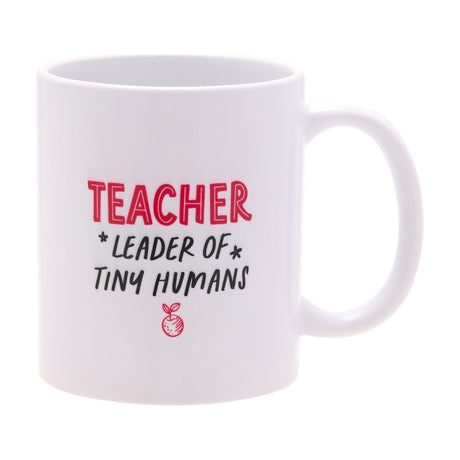 White stoneware mug with gloss finish, reading "TEACHER" in red and "LEADER OF TINY HUMANS" in black with a red apple icon, C-shaped handle, on a white background.