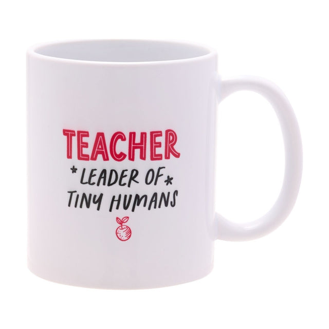 White stoneware mug with gloss finish, reading "TEACHER" in red and "LEADER OF TINY HUMANS" in black with a red apple icon, C-shaped handle, on a white background.