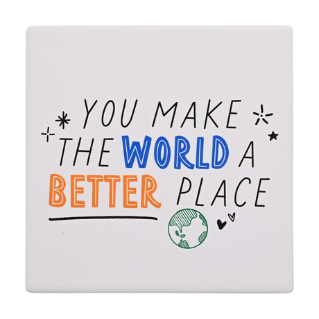 Square white matt stoneware coaster with hand-lettered "You Make the World a Better Place" text in black, blue and orange, decorated with a green globe, heart and stars, on a plain background.