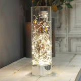 Beaded Glass LED Tube Light-Up Decoration, 30.5cm clear glass cylinder with illuminated silver bead wire and mirror-finish base, shown lit on a light wooden table.