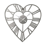 Open frame heart-shaped wall clock in matt grey metal, with Roman numerals on the outer heart and white hands on a central hub, shown on a plain white background.