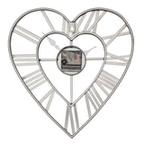 Open frame heart wall clock in matt grey iron with bold Roman numerals on the outer heart, slim spokes to a smaller inner heart and clock hands, shown on a plain white background.