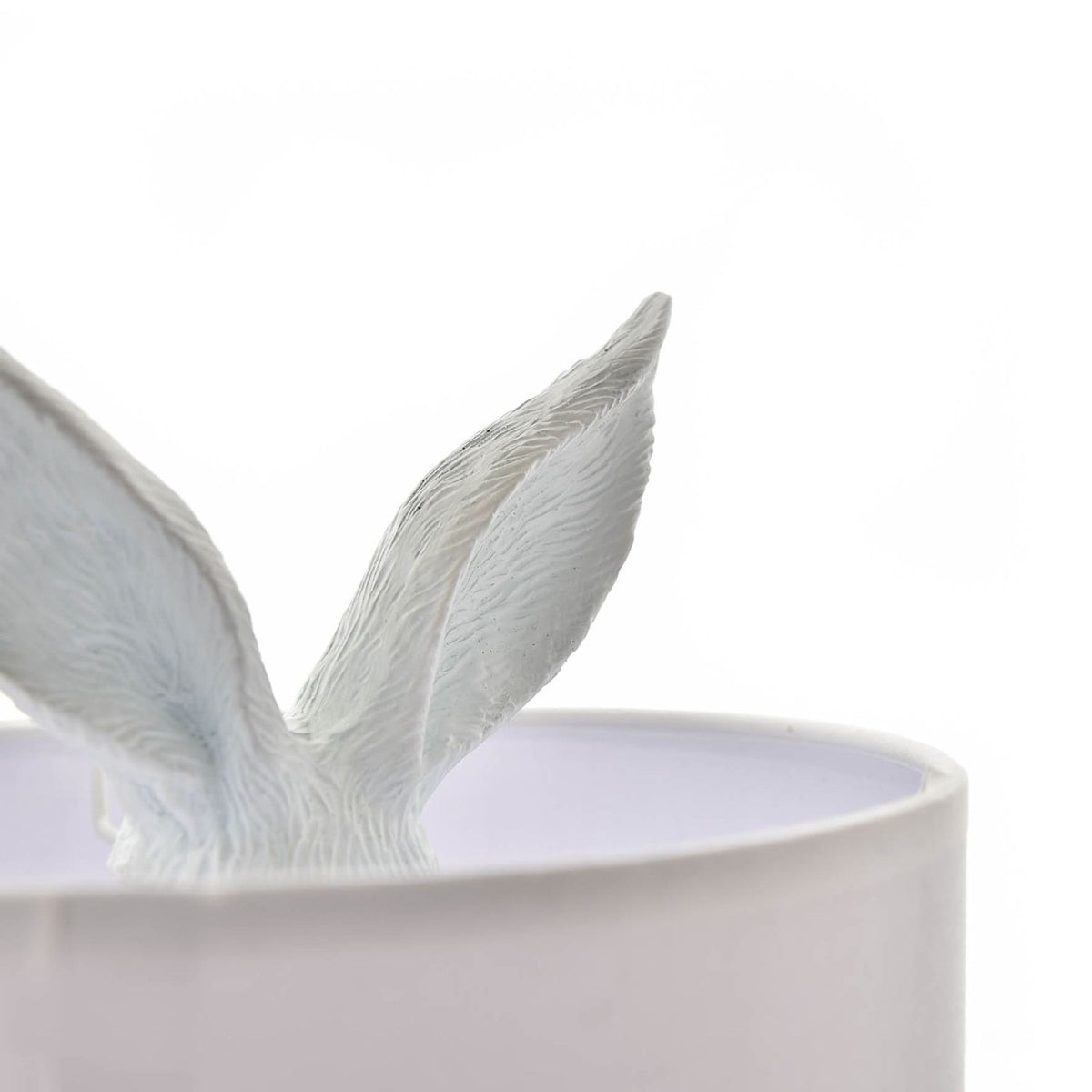 Close-up of the Seated Hiding Rabbit Table Lamp with Drum Shade 43cm in white, showing textured rabbit ears emerging from the white drum shade against a plain background.