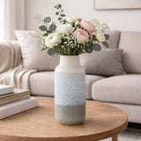 Reactive Glaze Textured Ceramic Bottle Vase 28cm in grey with cream neck, holding white and pink flowers and eucalyptus on a wooden coffee table in a living room.