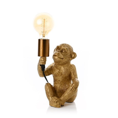 Gold Sitting Monkey Table Lamp, 24cm, seated figure holding a cylindrical E27 bulb holder with exposed filament bulb aloft, on a plain white background.
