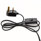UK 3-pin plug with inline rocker switch and black cable, shown coiled on a plain white background.