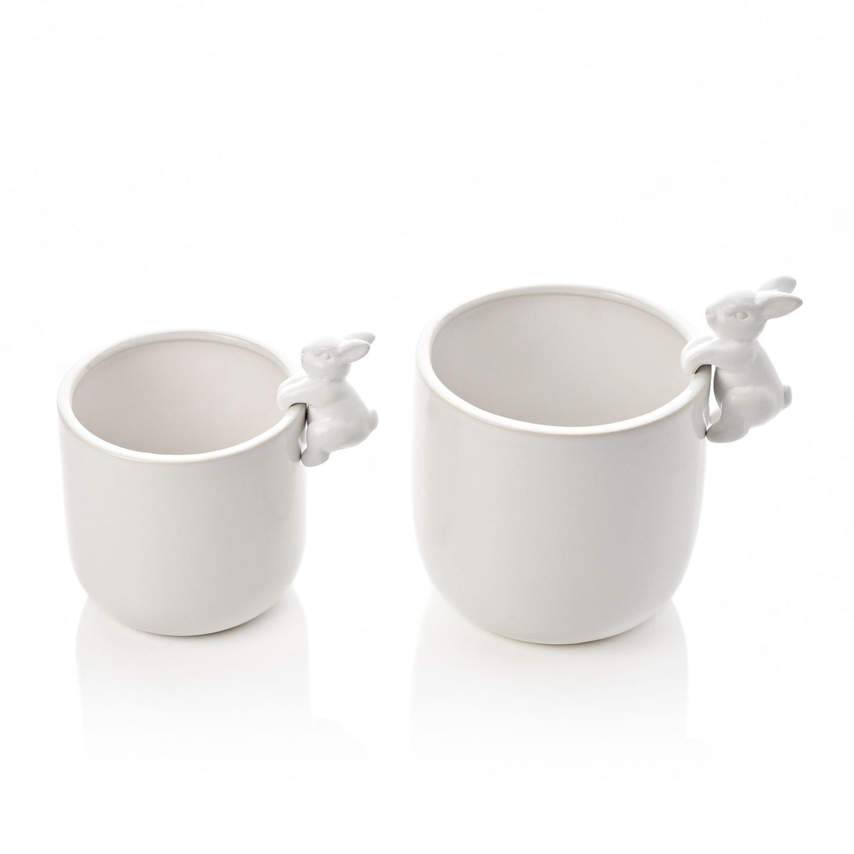 Set of two round white ceramic planters in different sizes, each with a small bunny perched on the rim, finished in glossy white glaze on a plain background.
