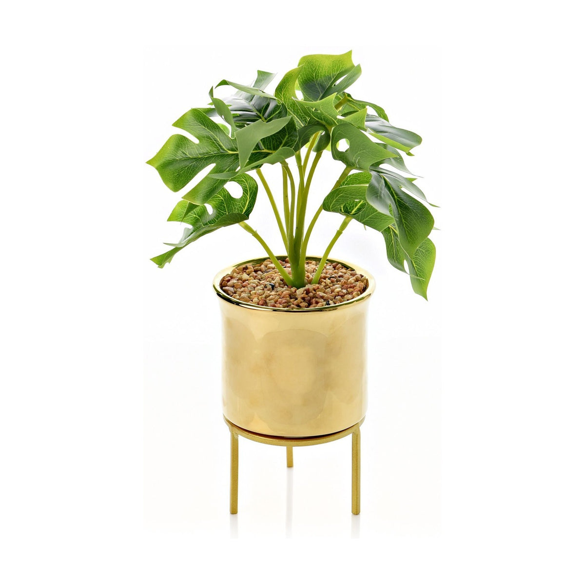 Footed gold iron planter with faux monstera foliage, glossy metallic cylindrical pot on a slim footed stand, 42cm tall, shown on a plain white background.