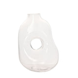 Abstract handmade clear glass vase with a short neck, softly rounded uneven body and a circular hole through its centre, shown on a plain white background.