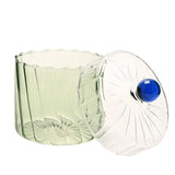Handmade ribbed glass trinket box with pale green base, clear lid featuring rippled lines and a round blue knob, shown open on a white background.