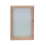 Wooden photo frame with a brown and white chevron stamped pattern bordering the rectangular opening, holds a 6 x 4in print, shown on a white background.