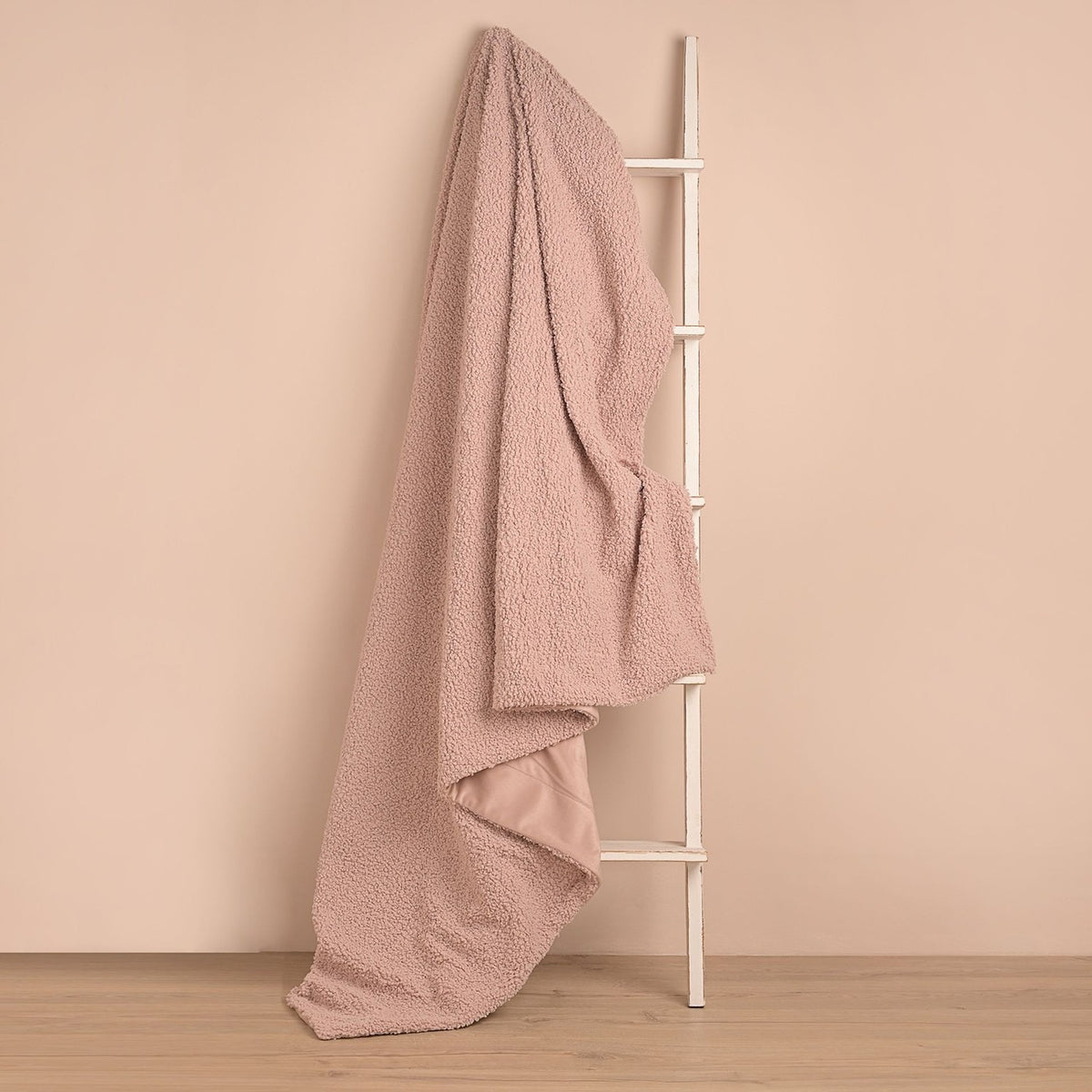 Pink Square Teddy Throw, 150cm x 150cm, in curly plush texture draped over a white ladder against a plain pink background.
