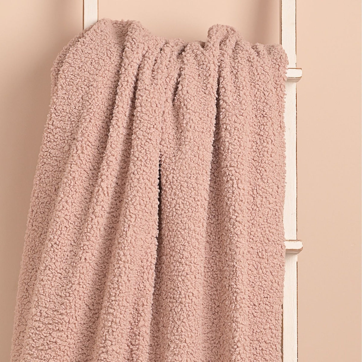 Pink Square Teddy Throw, 150cm x 150cm, in plush curly-textured fabric, draped over a white ladder against a soft pink wall.