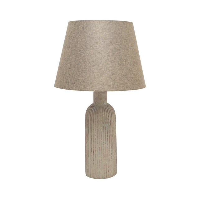 Slim ribbed bottle ceramic table lamp in beige with a weathered, flecked finish and tapered fabric shade, shown on a plain white background.