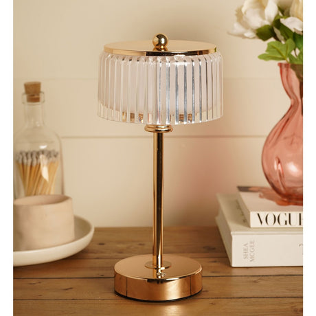 Crystal USB LED touch table lamp with gold base, slim stem and cap, ribbed clear shade, shown on a wooden sideboard beside books and a vase.