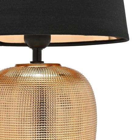 Close-up of the Grid Textured Round Ceramic Table Lamp 39cm in gold, showing the textured grid pattern base, black neck fitting, and tapered black shade with gold interior lining.