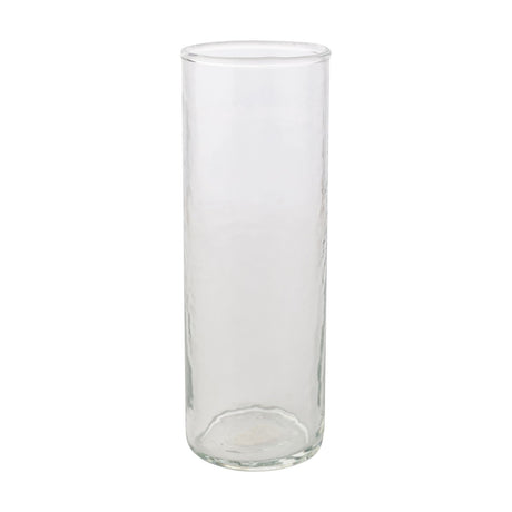 Tall straight-sided hammered style drinking glass in clear glass with a round base and smooth rim, shown on a plain white background.