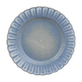 Small round stoneware plate with a fluted rim and scalloped edge, finished in a speckled blue glaze fading to grey-blue at the centre, shown on a plain white background.