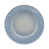 Round stoneware plate with a scalloped, fluted rim in mottled blue glaze fading to a pale grey-white centre, shown on a plain white background.