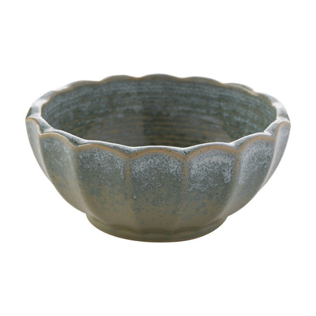 Scalloped fluted stoneware bowl in green with speckled glaze, petal-like rim panels and cream-edged ridges, shown on a plain white background.
