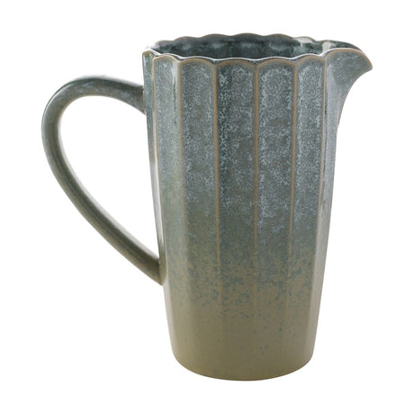Green ribbed stoneware jug with scalloped rim, speckled glaze fading to beige near the base, curved handle and pouring lip, on a white background.